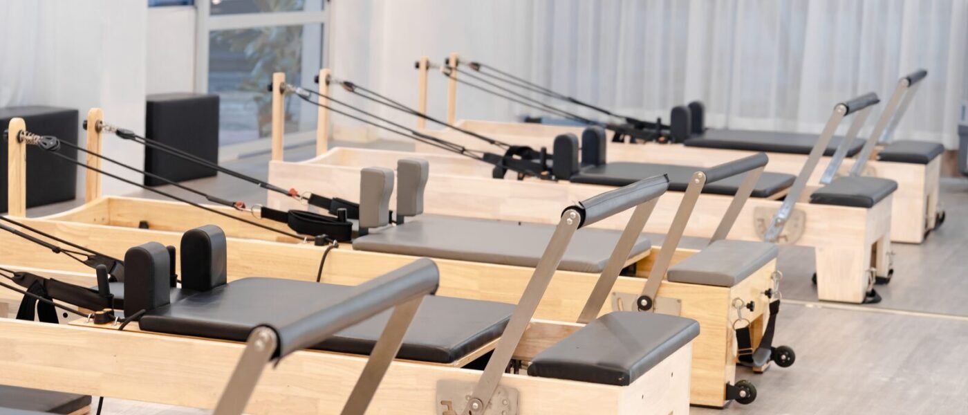 Studio de Pilates lumineux équipé de plusieurs reformers en bois alignés