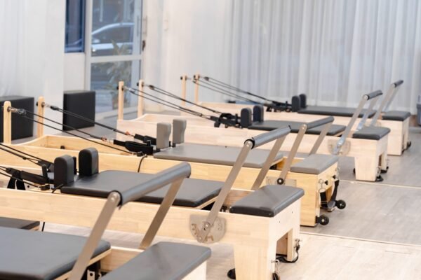 Studio de Pilates lumineux équipé de plusieurs reformers en bois alignés